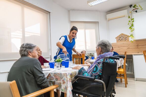 Infirmière souriante discutant avec une personne âgée